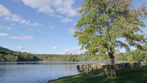 Wedding chairs outside next to large tree and lake Stock Footage 170382232