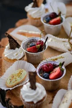 The wedding composition of delicious sponge fruit cakes decorated with juicy che Stock Photos
