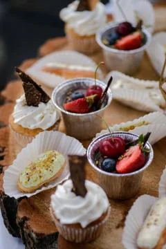 The wedding composition of delicious sponge fruit cakes decorated with juicy che Stock Photos
