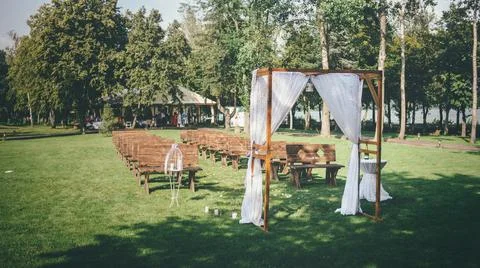 Wedding concept with a wedding arch located on a green lawn Stock Photos