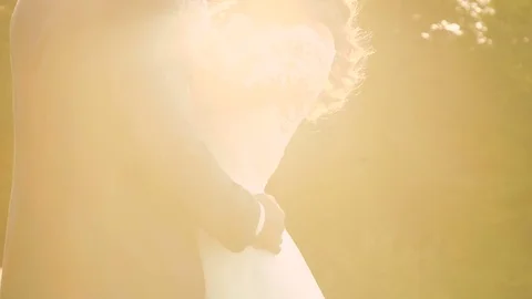 Wedding couple embracing in the striking golden sun light. Slowly Stock Footage