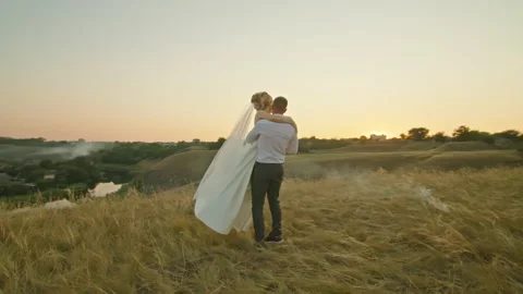 The wedding couple is having fun at sunset on the mountain hills by the river. Stock Footage 159366683