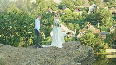 Wedding couple having fun at sunset on a rock near the river Stock Footage 159402738