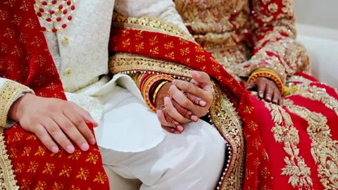 Wedding couple hold by the hand of each other, dressed in traditional red Indian Video stock 310283967