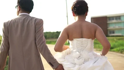 Wedding couple holding hands on sunset background shot in slow motion Stock Footage 77543771