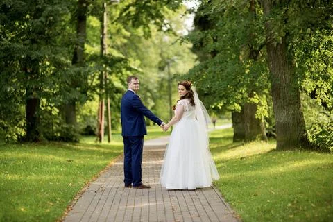 Wedding couple looking back while walking together Foto stock