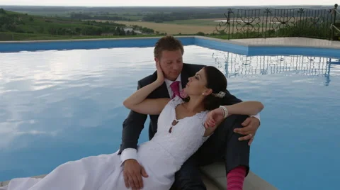 Wedding Couple Pool View Serious Giggle -  4k - Slow Motion Stock Footage 53082780