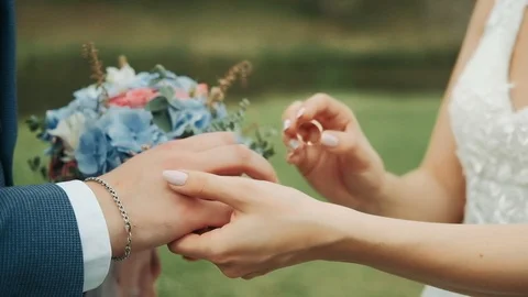 Wedding couple put on wedding rings at ceremony outdoors at summer sunny day Vídeos de archivo 114986331