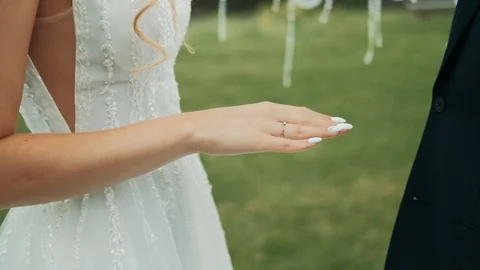 Wedding couple put on wedding rings at ceremony outdoors at summer sunny day Video stock 114986596