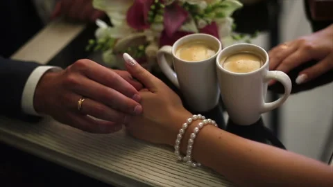 Wedding couple. Two Cups Of Coffee And Groomy Stroking Hands Of The Bride Stock Footage 90900926