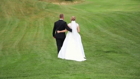 Wedding couple walking on a Golf course. Stock Footage 81812597