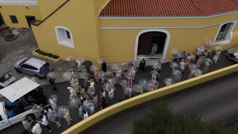 Wedding crowd exiting a historic yellow monastery building within a luxury Vídeos de archivo 325770126