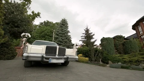 Wedding Day. Car Decorated With Flowers Exits From The Yard. Vídeos de archivo 108227341