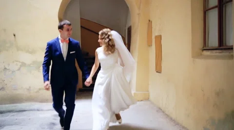 Wedding day, couple running cheering in ancient city  shot in slow motion  close 스톡 동영상 57454674