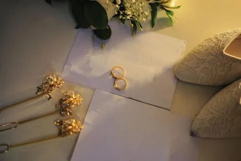 Wedding day essentials including gold rings shoes and floral hair accessories Stock Photos