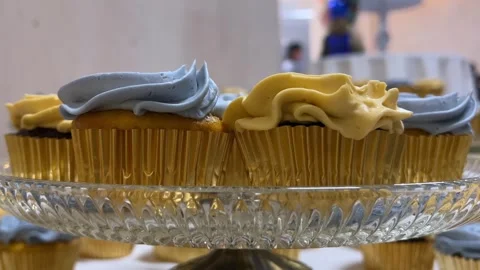 Wedding Day stock clip of blue and yellow frosted cupcakes on glass Stock Footage 247683083