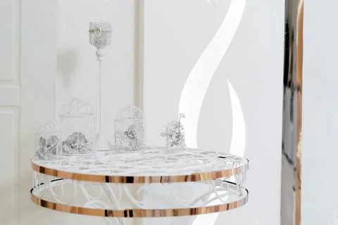 Wedding decor. On a bright table is a candlestick, with two baskets of orids  Stock Photos