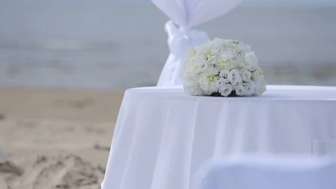 Wedding decorations of white fabrics and flowers on the beach before the Video stock 95248599