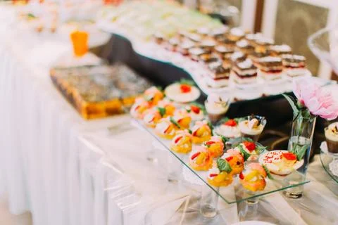 The wedding dessert table covered with delicious pastries with fruits. Foto stock