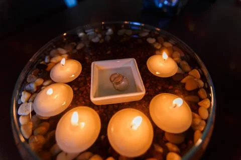 Wedding diamond ring with candles in the water. Stock Photos