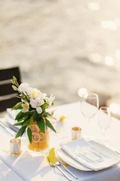 Wedding dinner table reception. Glass transparent bath with sliced lemons and a 스톡 사진