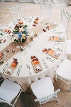Wedding dinner table reception. Round table with white tablecloth with brown Stock Photos