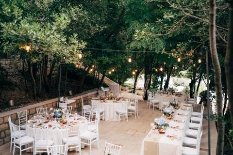 Wedding dinner table reception. Round tables with white tablecloths, brown Stock Photos