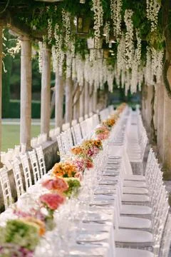 Wedding dinner table reception. A very long table for guests with a white ... Stockfoto's