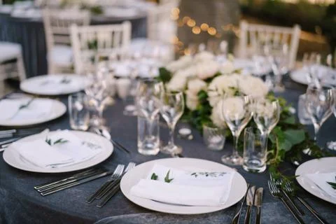 Wedding dinner table reception. White round plates on a round table with gray Foto stock