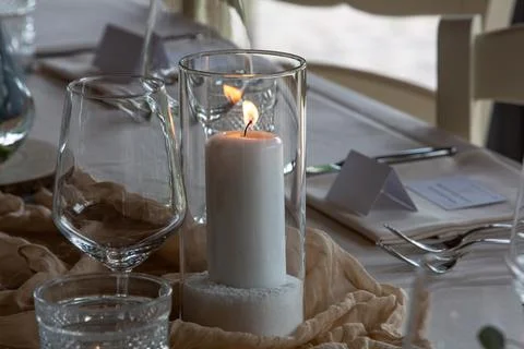 Wedding dinner table setting with lit candle Stock Photos