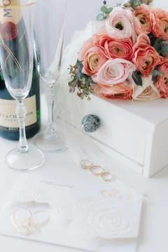 Wedding elements: pink small bouquet, rings, champagne and invitation cards i Stock Photos