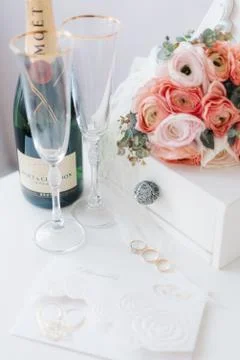 Wedding elements: pink small bouquet, rings, champagne and invitation cards i Stock Photos
