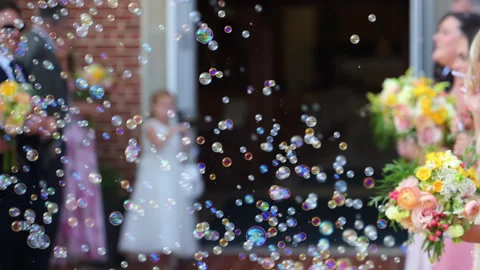 Wedding exit at church with soap bubbles in the air. Bride and guests Stock Footage 330986644