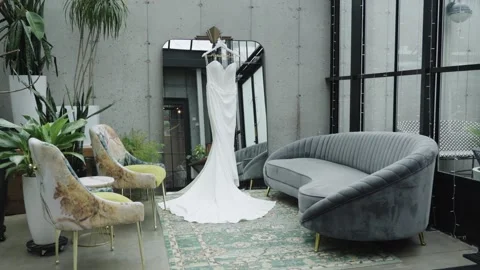Wedding Gown Displayed in Modern Loft with Greenery and Velvet Sofa Stock Footage 337115874