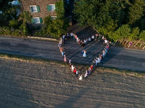 Wedding guests lined up in the shape of heart with bride and groom marriage p Stock Photos