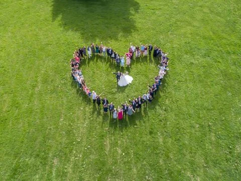 Wedding guests lined up in the shape of heart with bride and groom marriage p Stock Photos