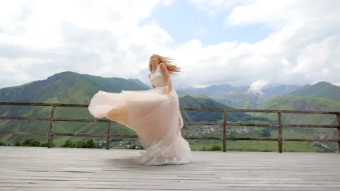 Wedding. Happy red-haired bride dancing against the background of mountains Stock Footage 90885761