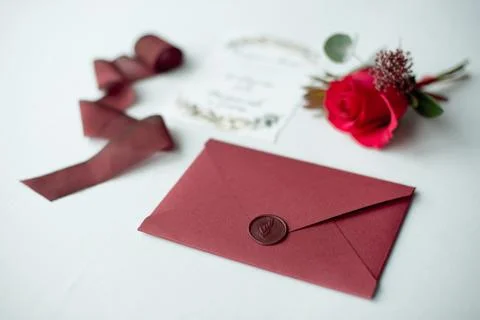 Wedding invitation as a decorated letter on a white tablecloth with a flower Stock Photos