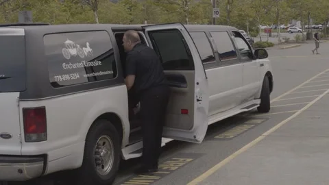Wedding limo. The driver opening guest door. 库存影片 144236723