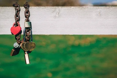 Wedding locks with a heart shape hanging on an iron chain on a w Stock Photos
