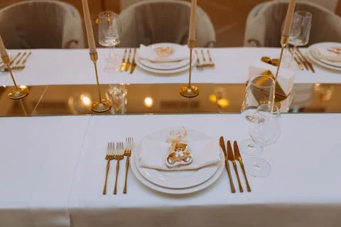 Wedding luxury table setting crystal wine glass and gold forks and knives. .. Stock Photos