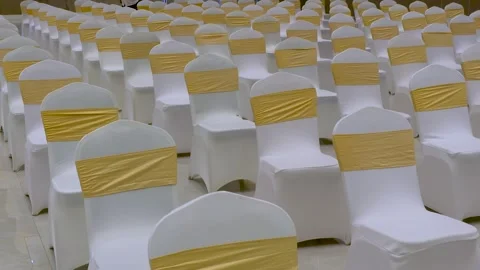 Wedding or party chairs in a large hall wrapped with white fabric and yello.. Stock Footage 317359848