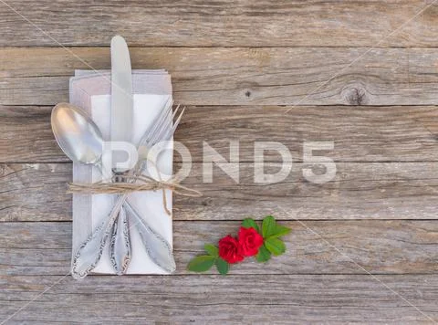 Wedding or Valentine day table setting with arranged silverware and red rose Stock Photos