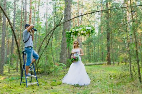 Wedding photographer using stepladder to make pictures of the bride Stock Photos