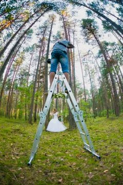 Wedding photographer using stepladder to make pictures of the bride Stock Photos