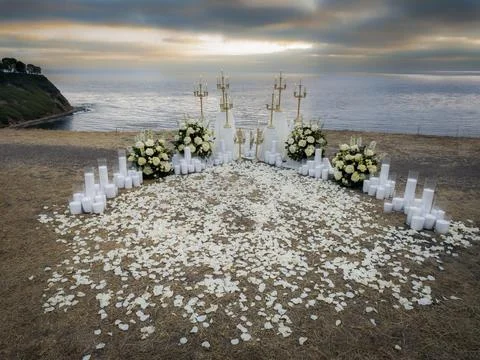 Wedding proposal setup on the coast during a dramatic sunset Photos