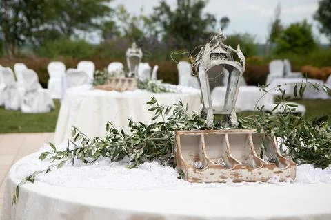 Wedding reception decorated table with olive branch and lantern centerpiece 스톡 사진