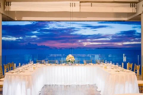 Wedding reception dinner table setting during sunset with ocean view Stock Photos
