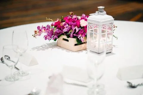 The wedding reception dinner table setup decorated with the candle and flowers. Фото