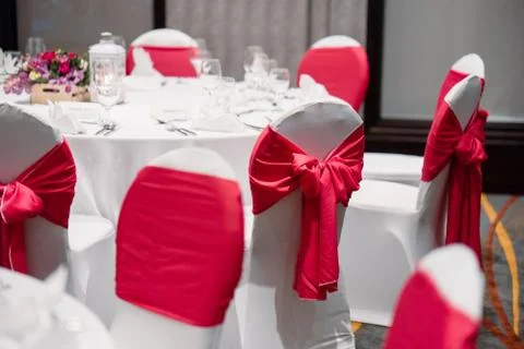 Wedding reception dinner table, white and red theme chairs Stock Photos